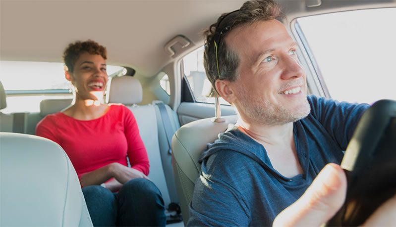 Rideshare driver with happy, smiling passenger